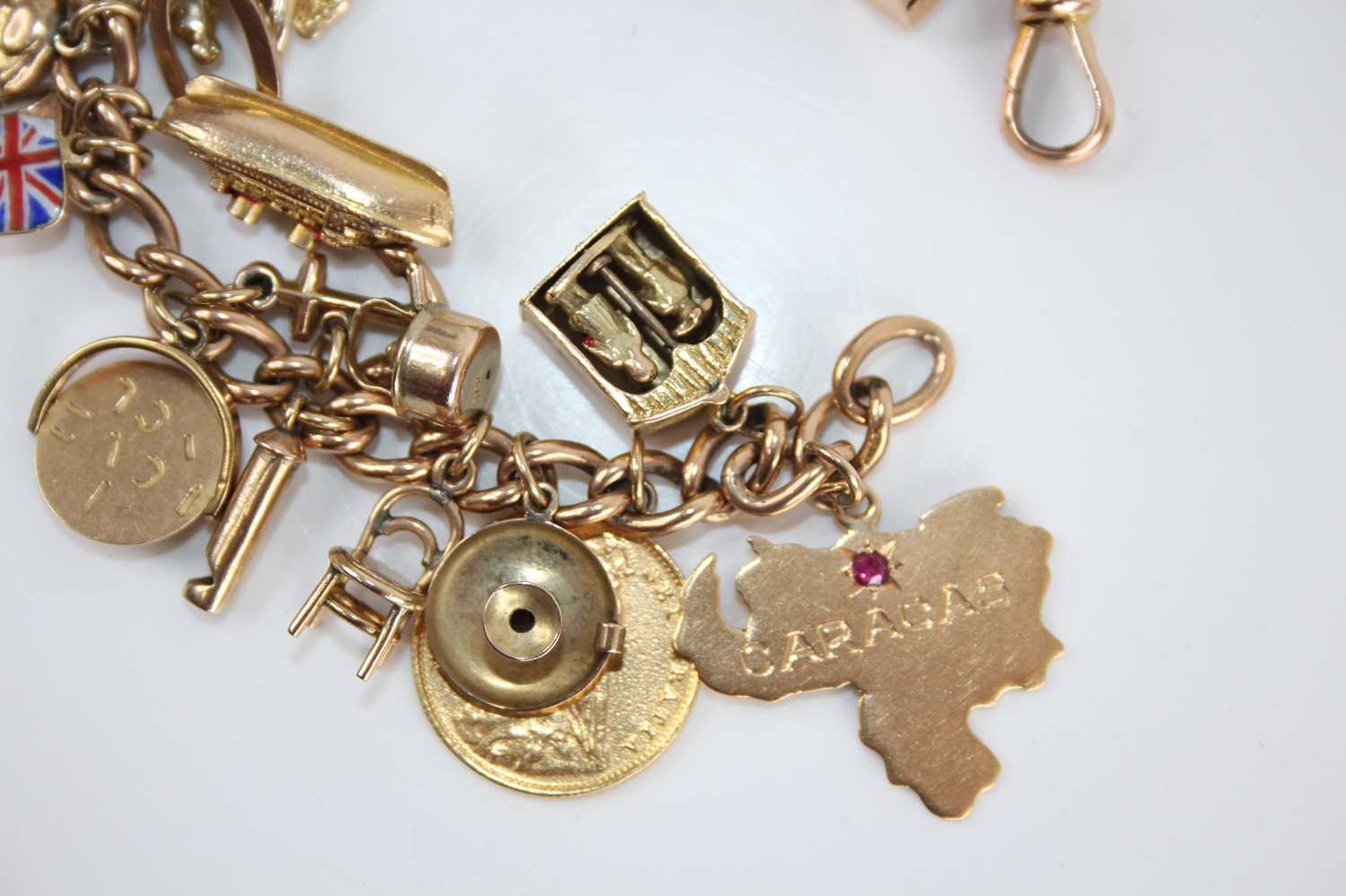 A 9ct gold curblink bracelet containing a collection of charms, principally in 9ct gold and to - Image 2 of 5