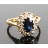 An 18ct yellow and white gold, sapphire and diamond oval cluster ring, featuring a centre oval