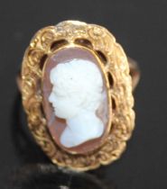 A yellow metal carved shell cameo set ring, depicting profile portrait of a young Roman male and