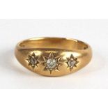 An 18ct gold diamond three-stone ring, the three stones each being 'gypsy' set round cuts, the