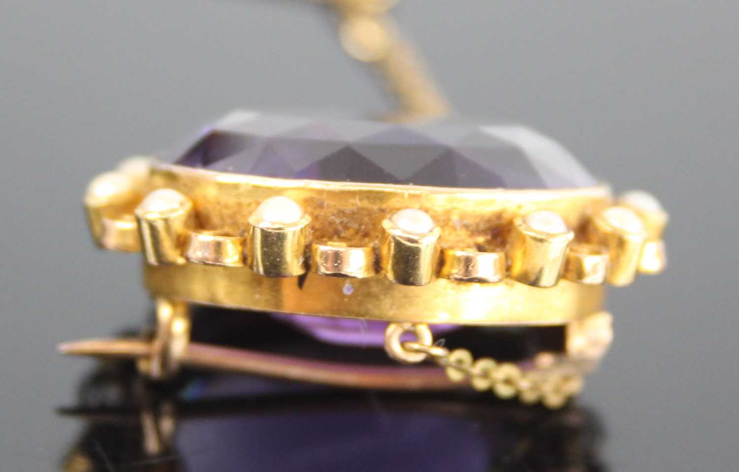 A yellow metal, amethyst and pearl oval cluster brooch, featuring a centre oval amethyst bezel set - Image 4 of 4