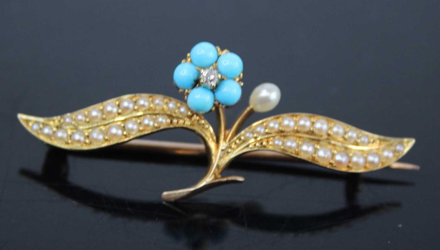 A yellow metal, seed pearl, turquoise and diamond set leaf and flower bar brooch, the flower centred