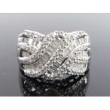 A white metal diamond multi-row crossover style dress ring, featuring 66 round brilliant and 42