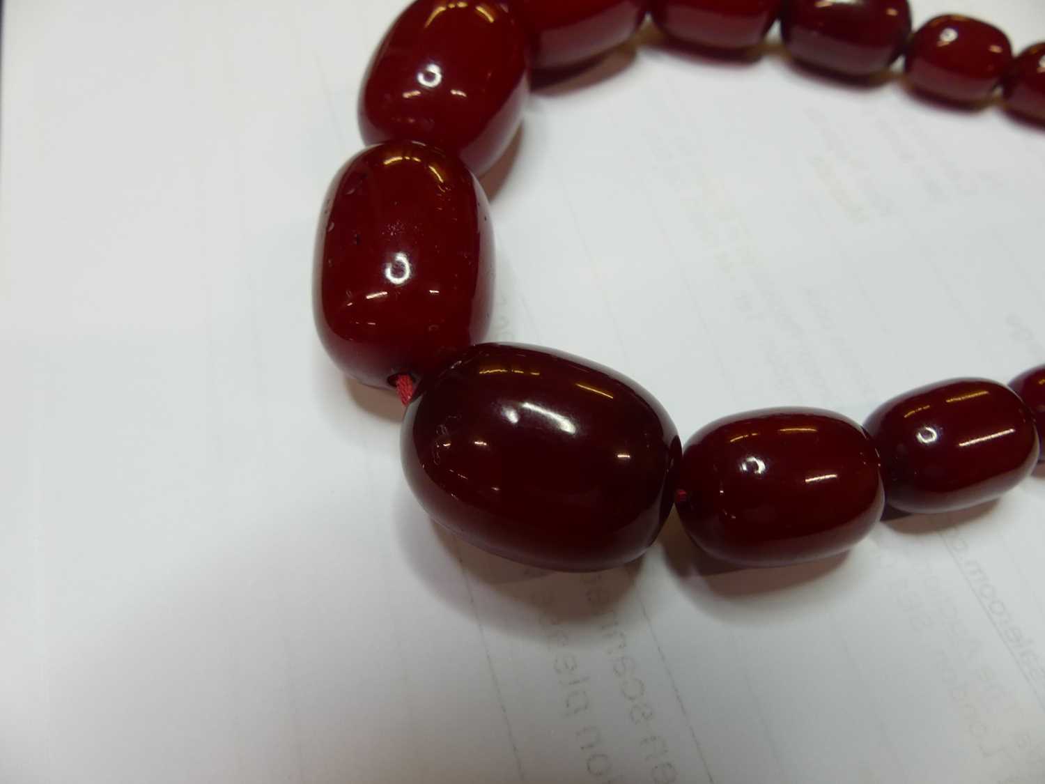 A cherry amber single string necklace, arranged as 40 graduated barrel beads, the largest w.25mm, - Image 7 of 14