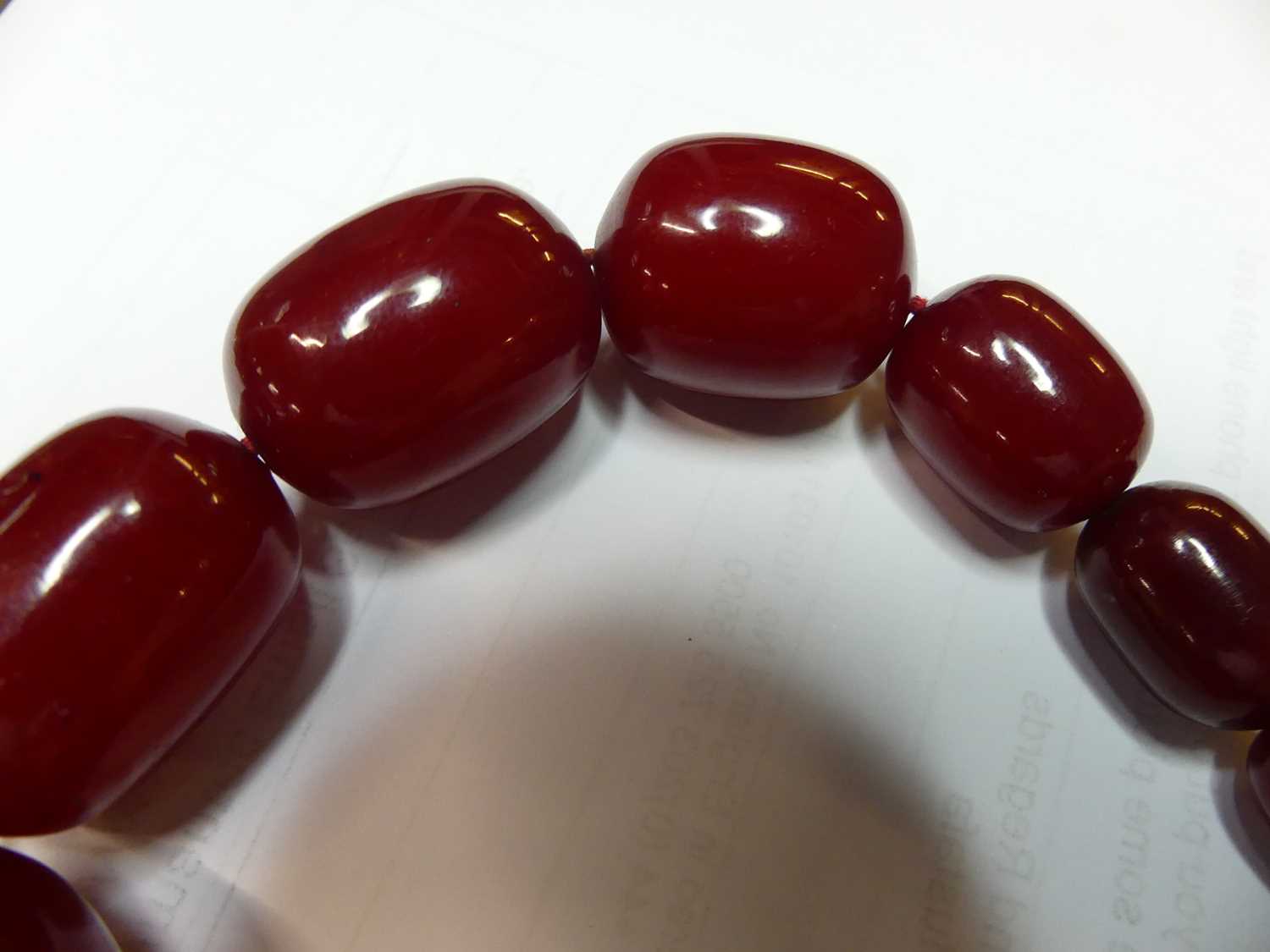A cherry amber single string necklace, arranged as 40 graduated barrel beads, the largest w.25mm, - Image 6 of 14