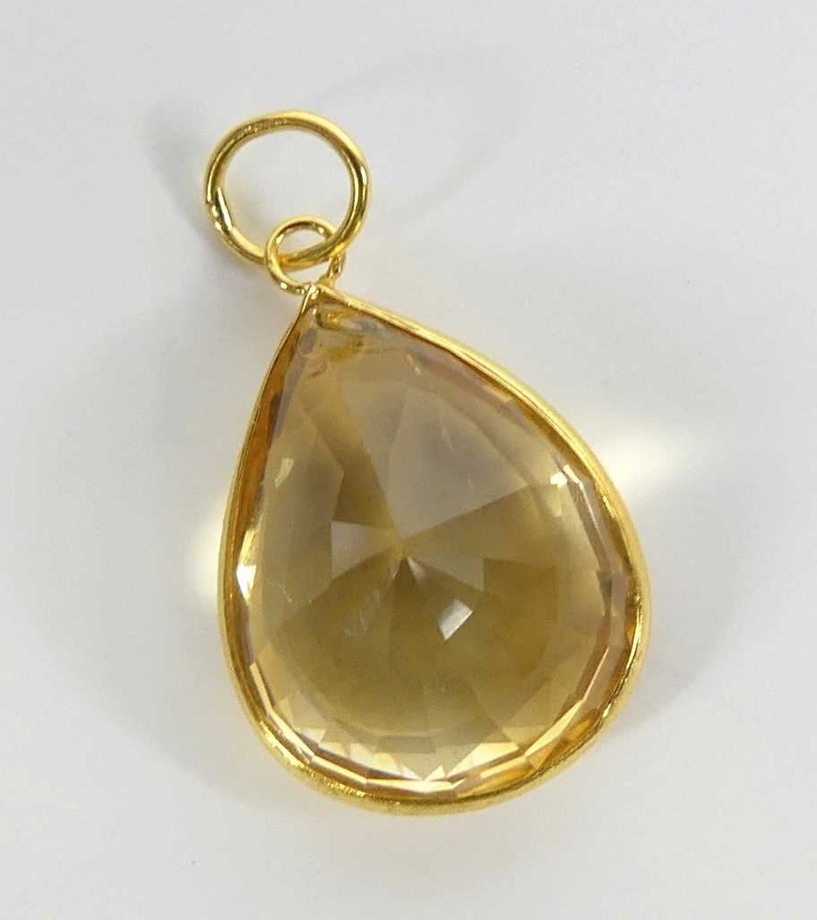 A yellow metal citrine pendant, having a pear cut citrine in a bezel setting, citrine dimensions