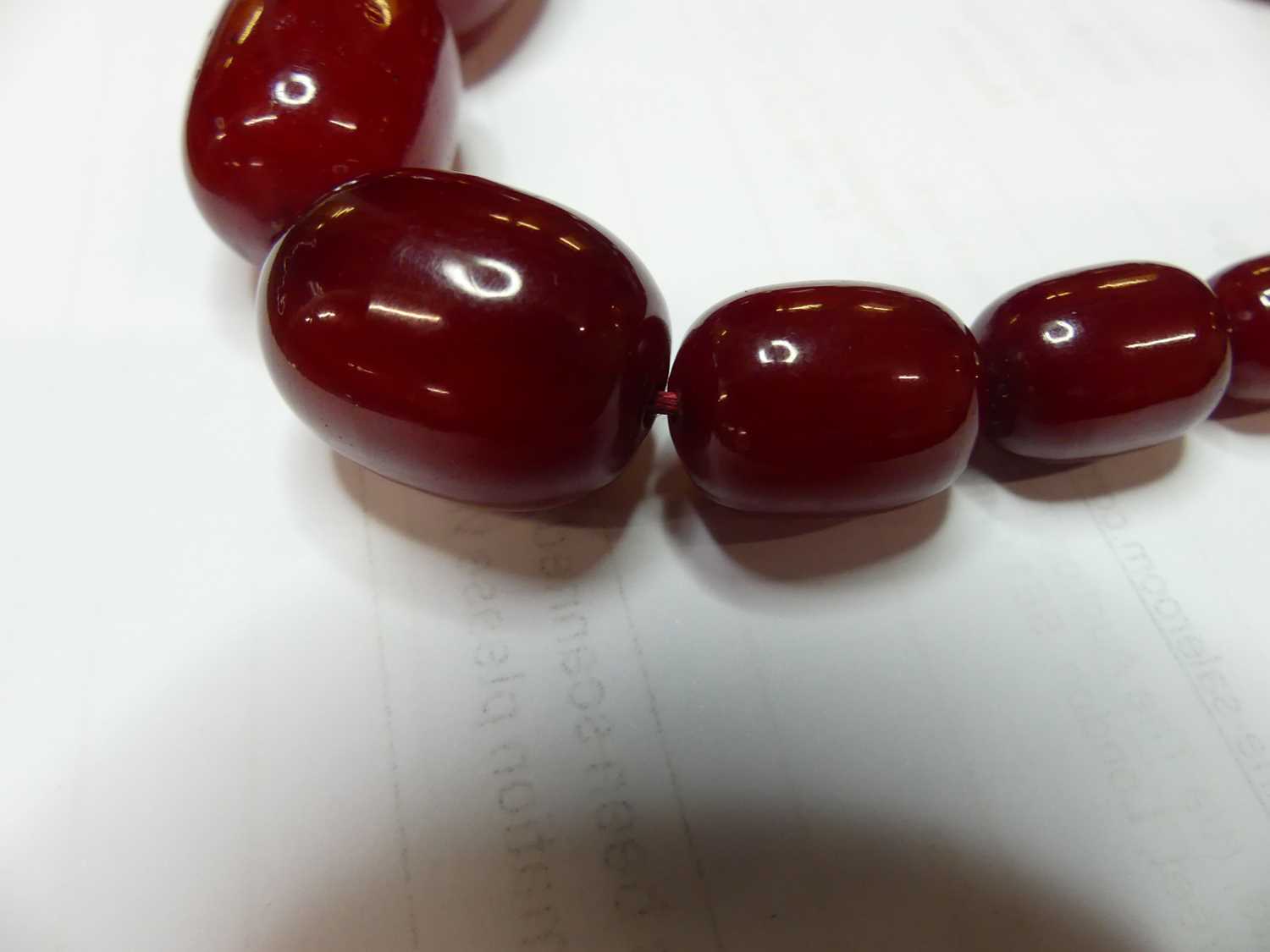 A cherry amber single string necklace, arranged as 40 graduated barrel beads, the largest w.25mm, - Image 5 of 14