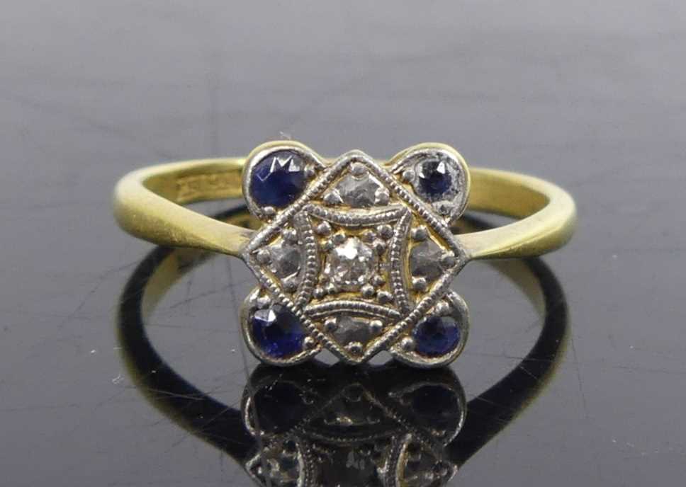 A yellow and white metal, sapphire and diamond quatrefoil cluster ring, featuring a centre Old