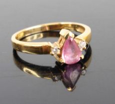 A modern 18ct gold pink sapphire and diamond highlight dress ring, the pear cut sapphire measuring
