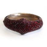 A late Victorian rose cut garnet pavé set hinged and domed cluster bangle, the whole set with