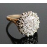 A yellow and white metal diamond oval cluster ring, featuring 29 round brilliant cut diamonds in
