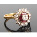 An 18ct gold ruby & diamond flowerhead cluster ring, arranged as a centre four-claw set round cut