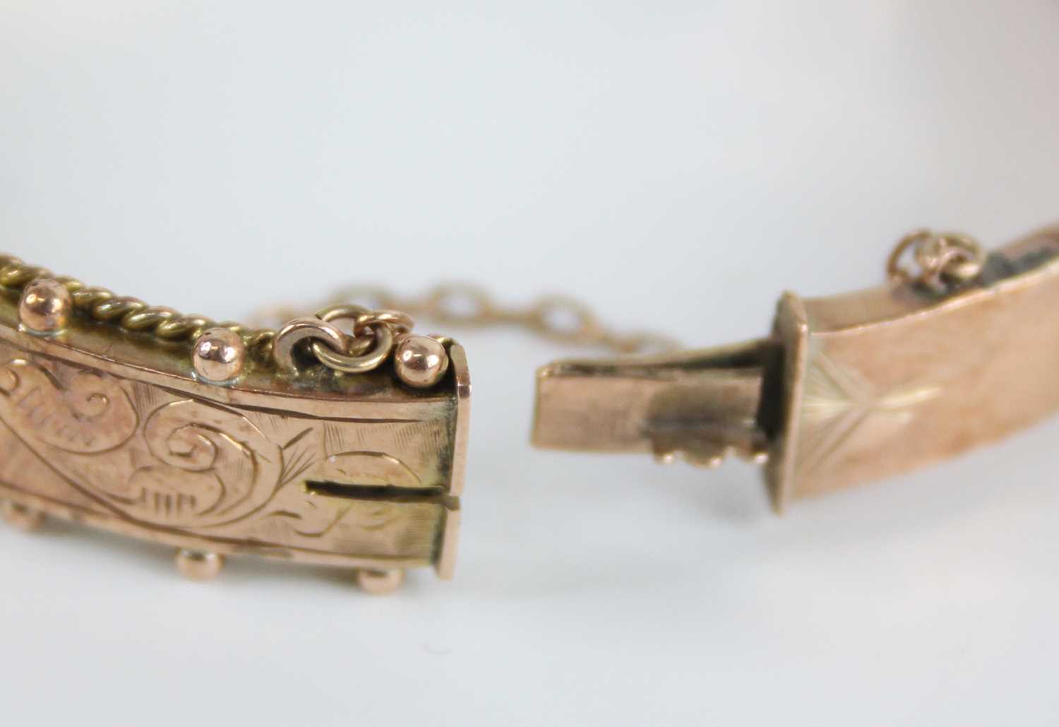 An Edwardian 9ct gold hinged hollow bangle, one side having engraved scroll leaf decoration within a - Image 4 of 5