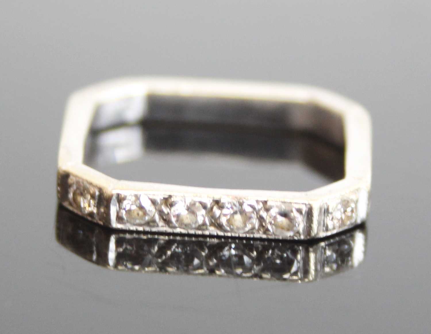 A white metal diamond octagonal shaped half eternity ring featuring 6 round brilliant cut diamonds