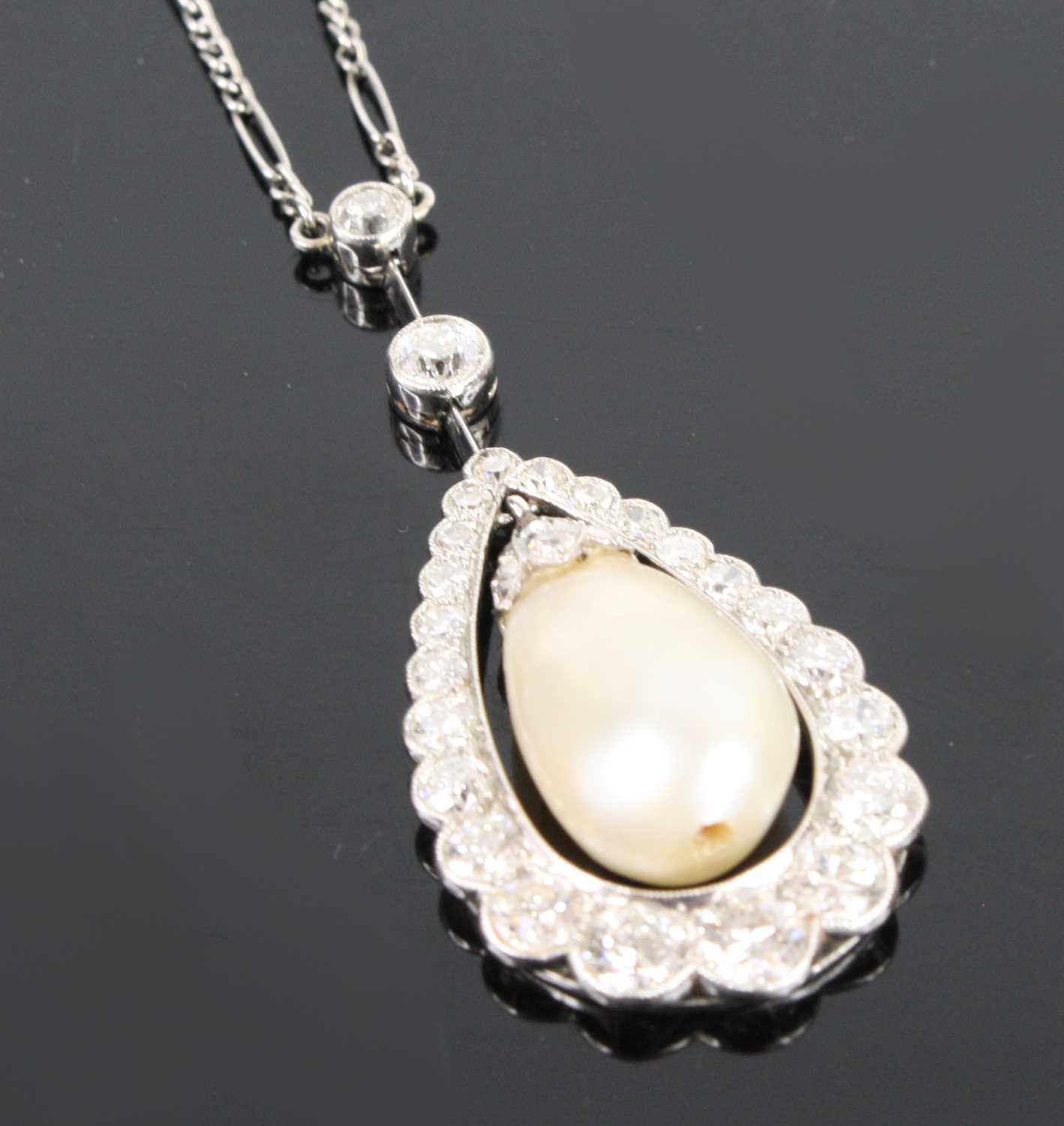 A white metal articulated pearl and diamond pear shaped cluster pendant, comprising a 16.5 x 10.15mm