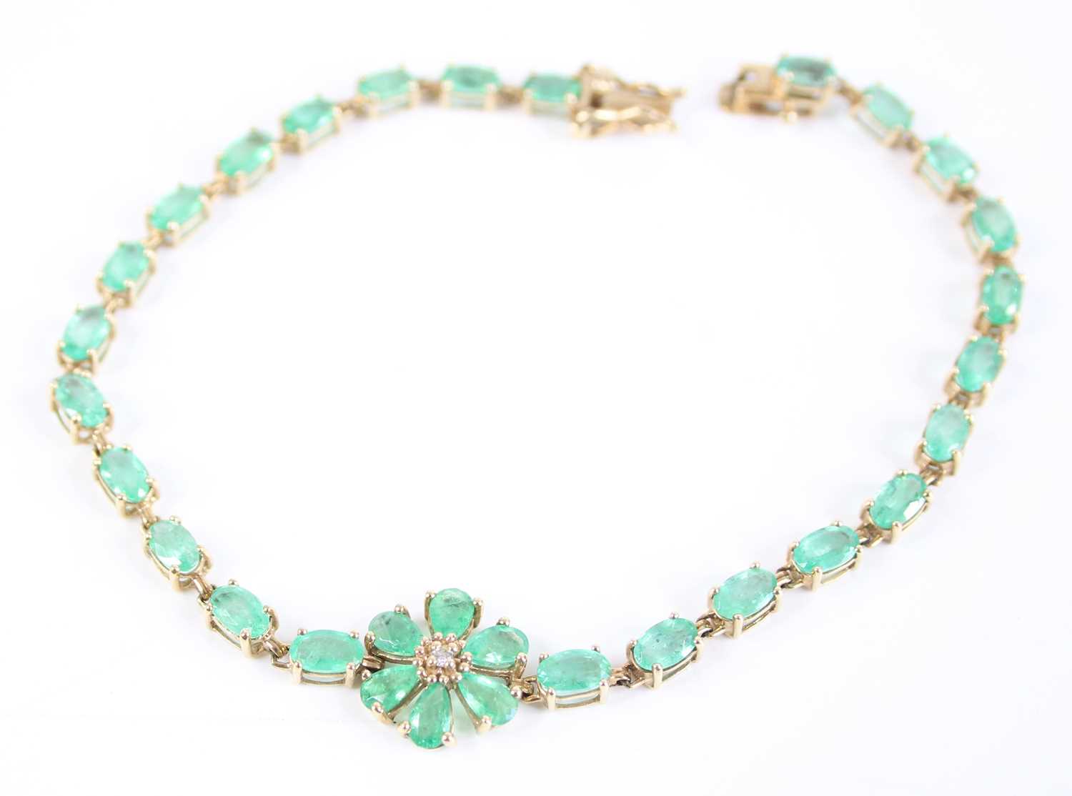 A 9ct yellow gold emerald multi-stone bracelet, comprising a centre flower motif with six pear cut