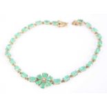 A 9ct yellow gold emerald multi-stone bracelet, comprising a centre flower motif with six pear cut