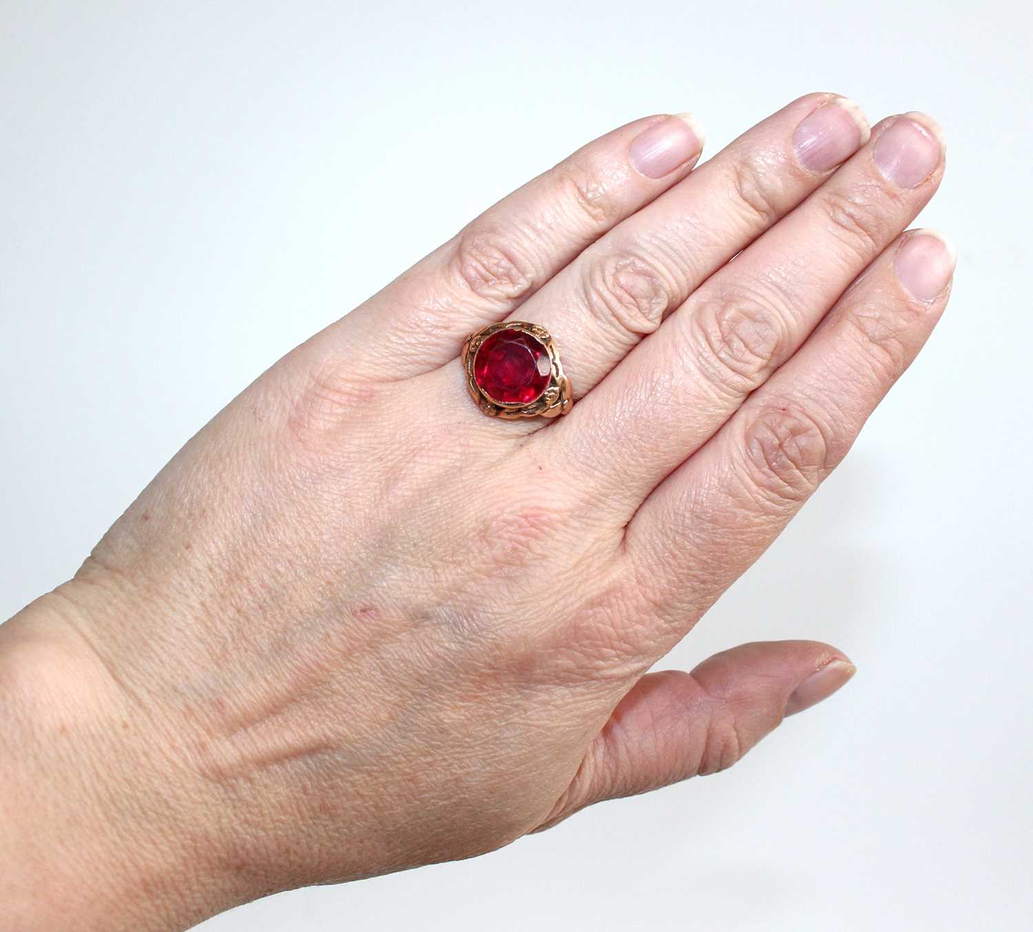 A yellow metal and synthetic ruby set dress ring, the large round cut red stone measuring approx - Image 6 of 6