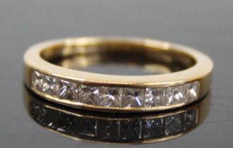 An 18ct gold diamond half eternity ring, arranged as nine channel set Princess cuts, total diamond