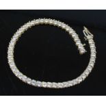 A yellow metal cubic zirconia tennis bracelet, featuring fifty-one 3 x 1.9mm round cubic zirconia in