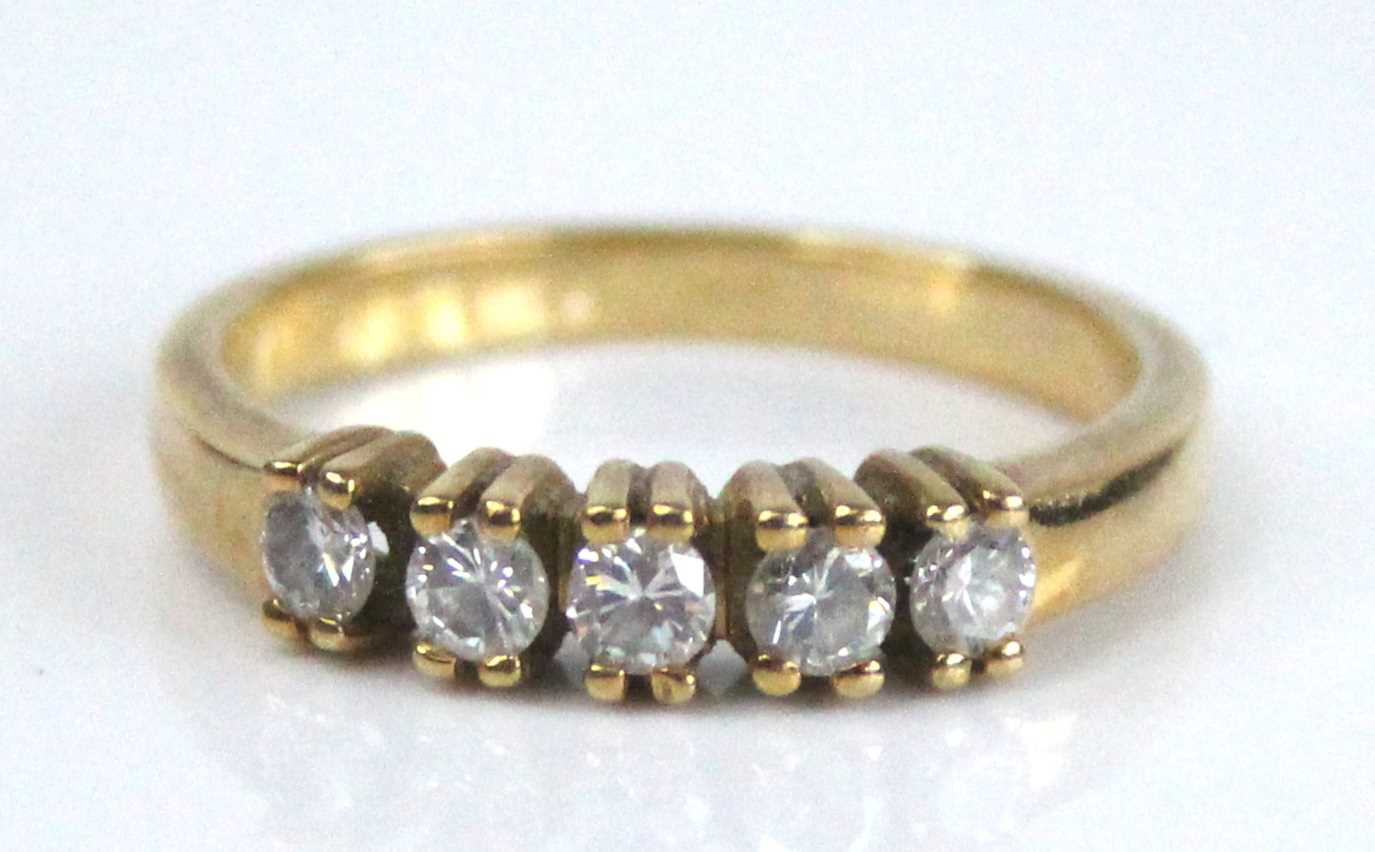 A yellow metal diamond half eternity ring, having five round brilliant cut diamonds in claw