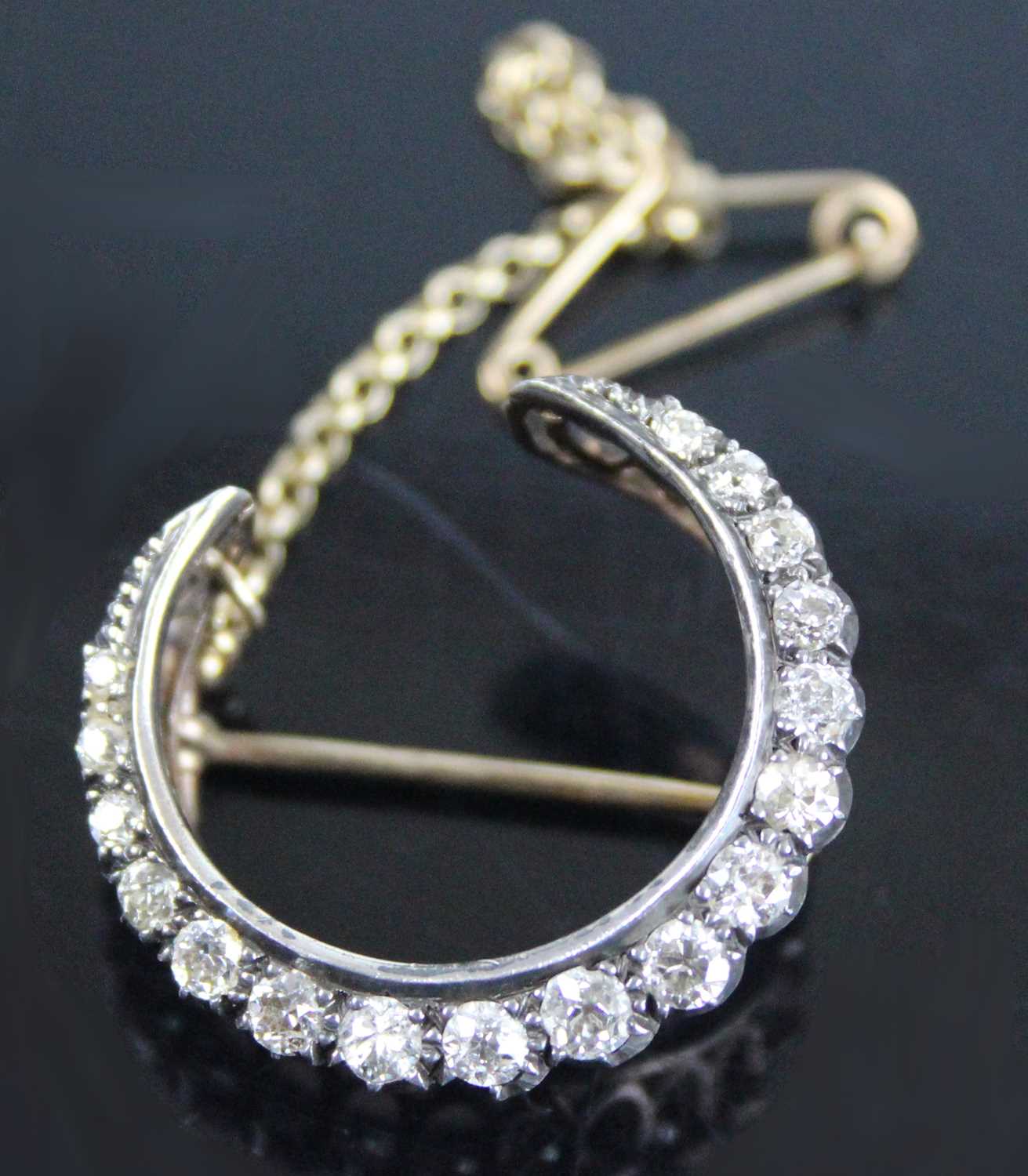 A late Victorian yellow and white metal, diamond crescent brooch, featuring 17 graduated Old