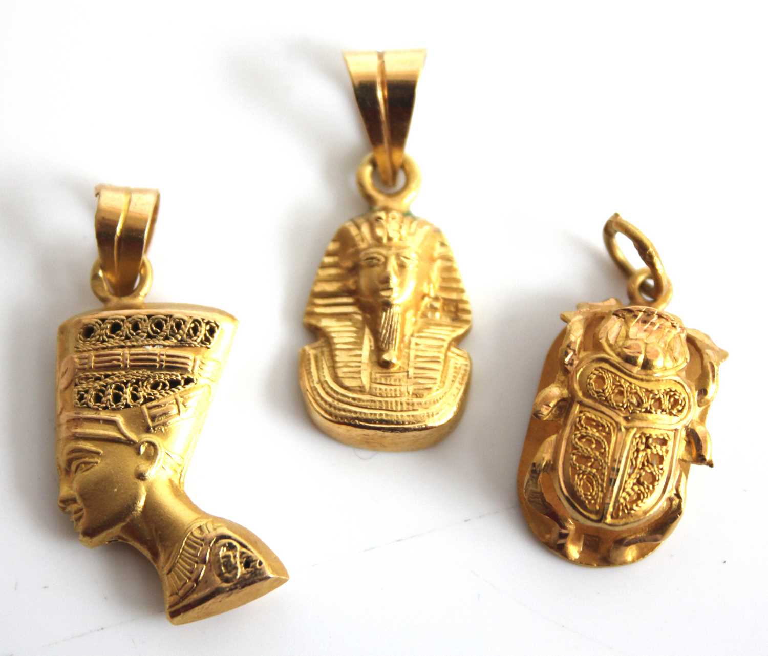 A Middle Eastern yellow metal pendant depicting King Tut, 2cm (excluding pendant bale); together