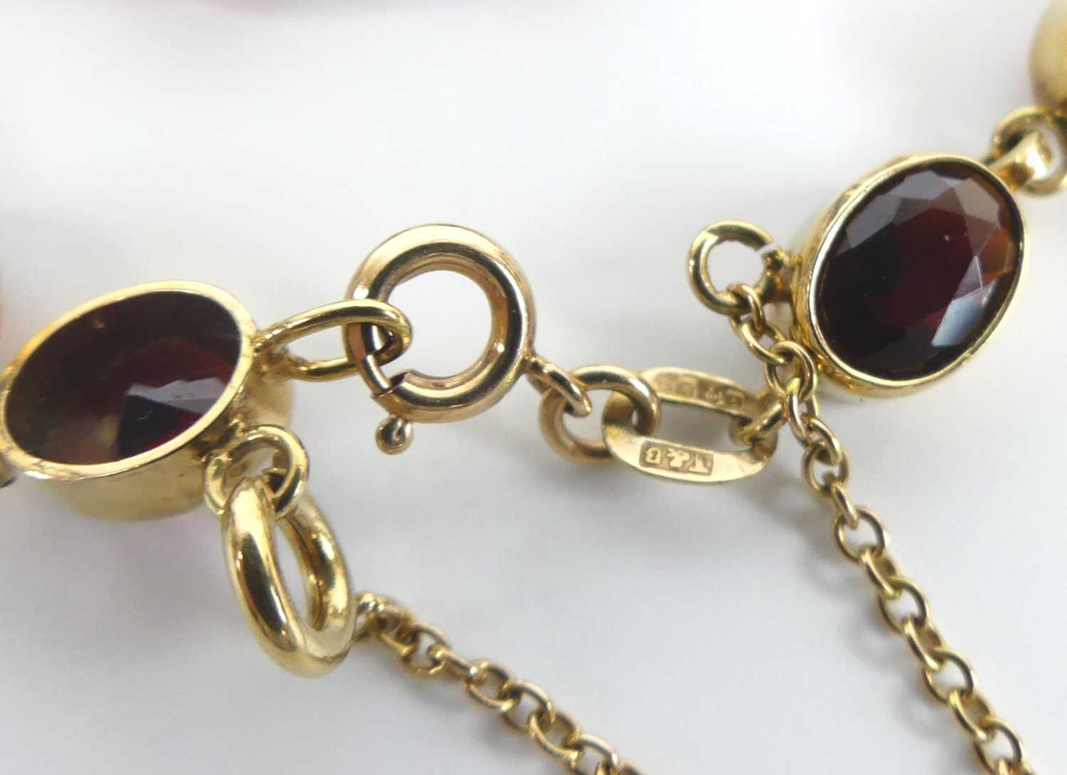 A 9ct yellow gold garnet bracelet, comprising 13 oval almandine garnets in bezel settings, with bolt - Image 4 of 4