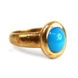 An Arts & Crafts yellow metal cabochon turquoise set dress ring, the turquoise measuring approx 7.