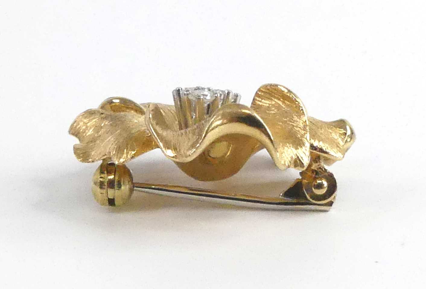 A yellow metal diamond set stylised flower brooch, featuring three round brilliant cut diamonds claw - Image 3 of 4