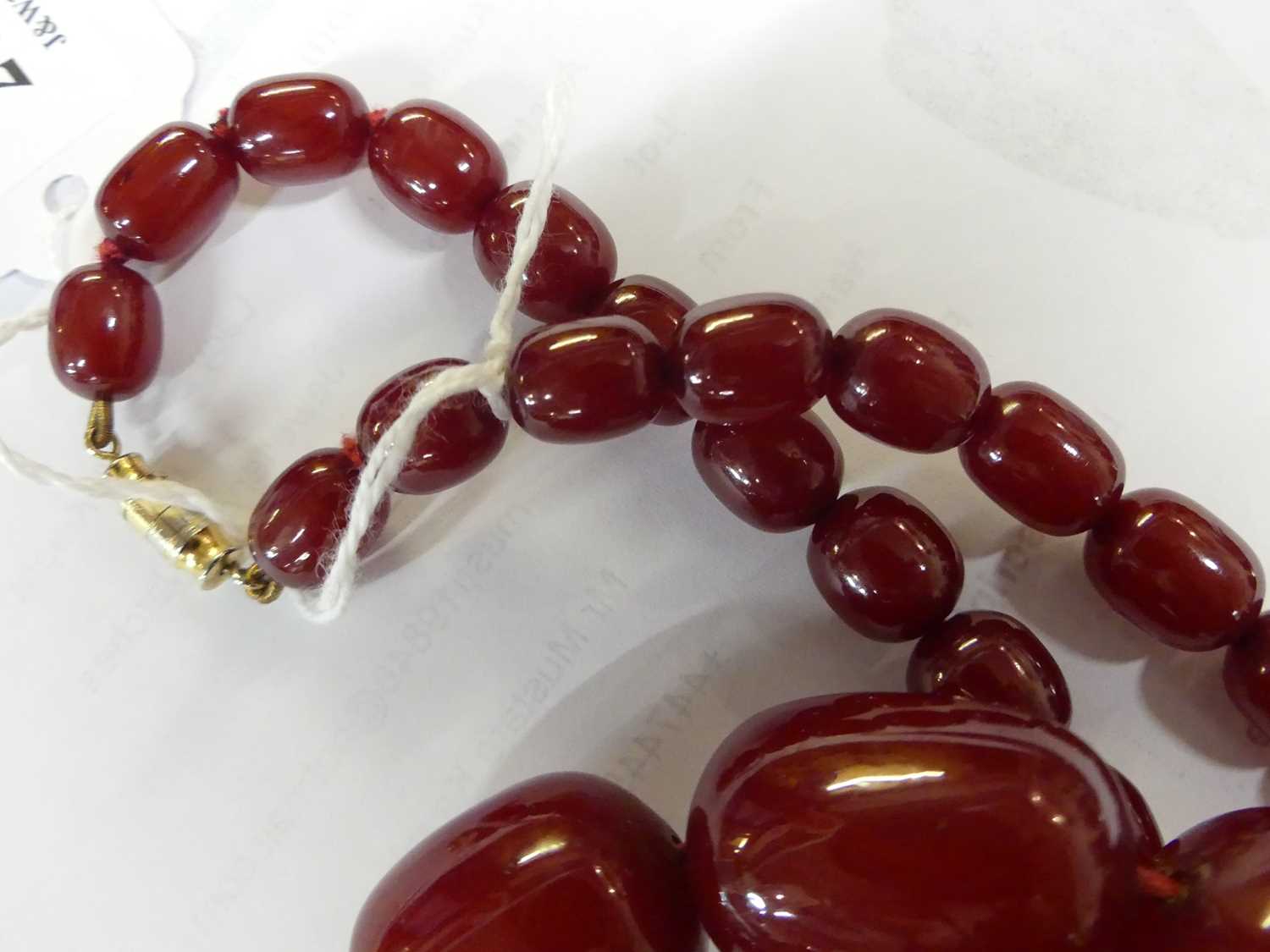 A cherry amber single string necklace, arranged as 40 graduated barrel beads, the largest w.25mm, - Image 10 of 14