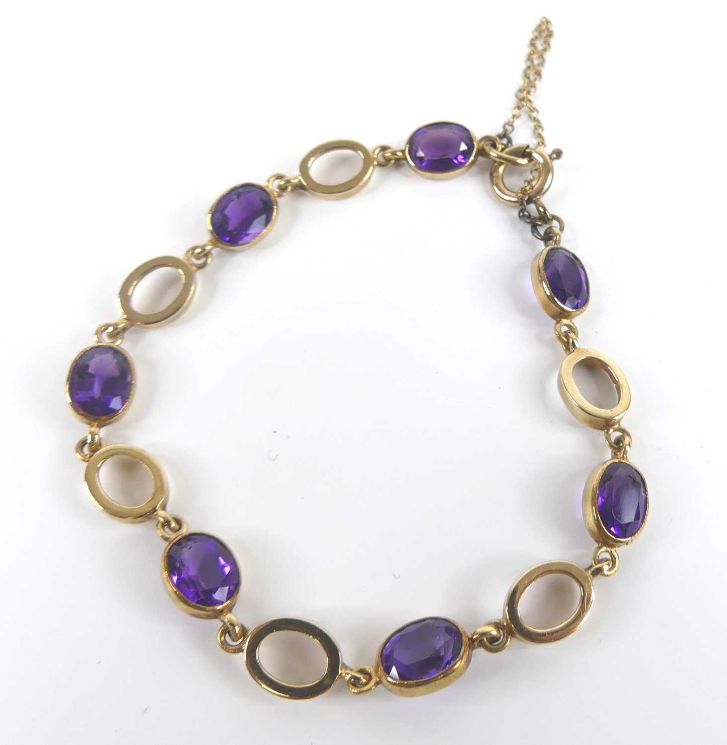A 9ct yellow gold amethyst bracelet, featuring seven oval amethysts alternating with open oval - Image 2 of 4