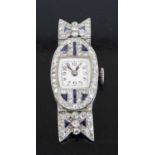 An Art Deco platinum sapphire and diamond set cocktail watch having a signed silvered Arabic dial