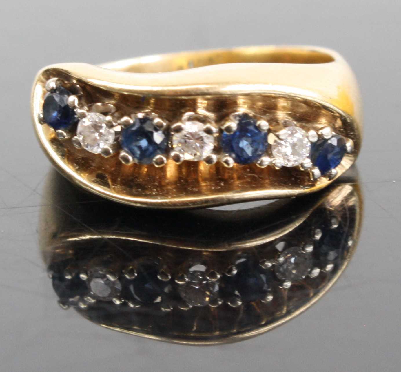 A 14ct gold sapphire and diamond half hoop ring arranged as seven alternating stones, total