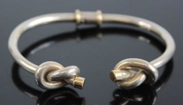 A Gucci silver and 18ct gold tipped bangle, having knotted ends and twist action, 34g, 7cm, boxed