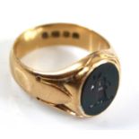 An 18ct gold and bloodstone set gent's signet ring, the bloodstone with relief carved armorial,