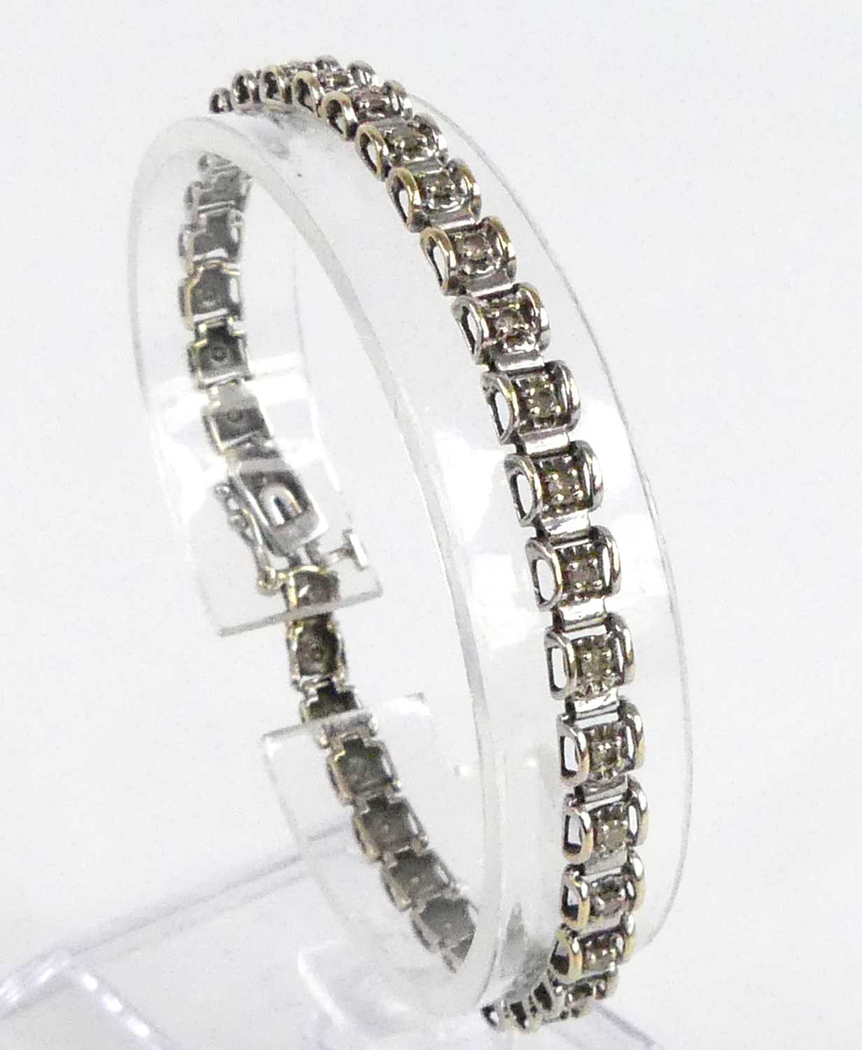 A 9ct white gold diamond tennis style bracelet, having box clasp and figure-of-eight safety catch,