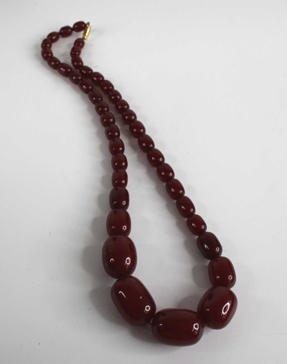 A cherry amber single string necklace, arranged as 40 graduated barrel beads, the largest w.25mm, - Image 2 of 14