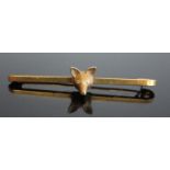 An 18ct gold safety pin bar brooch set with a fox's head, the eyes as two round cut diamonds,