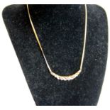 A modern 9ct gold, ruby and diamond set necklet, the elliptical setting set with alternating rows of