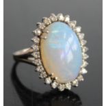 A 9ct white gold, opal and diamond oval cluster ring, comprising a central opal cabochon within a