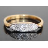 An Art Deco 18ct gold diamond three-stone ring, the elliptical setting being milligrain set with