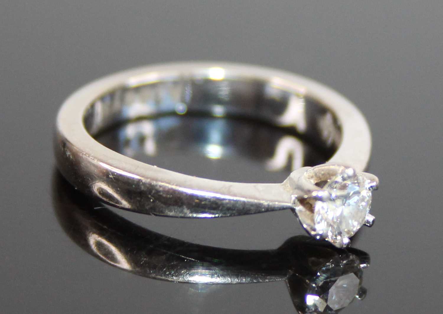 An 18ct white gold diamond solitaire ring, featuring a round brilliant cut diamonds in a six-claw