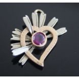 After Cartier, a yellow and white metal ruby abstract heart pendant, the oval ruby measuring 4.45 by