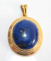 An 18ct yellow gold and lapis lazuli pendant, the cabochon stone measuring approx 17 x 14.4 x 7mm,