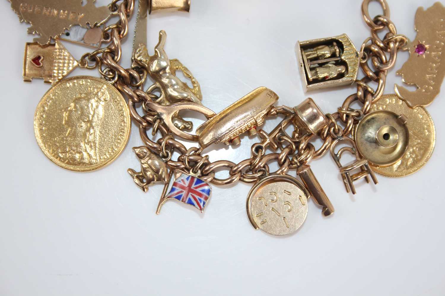 A 9ct gold curblink bracelet containing a collection of charms, principally in 9ct gold and to - Image 3 of 5