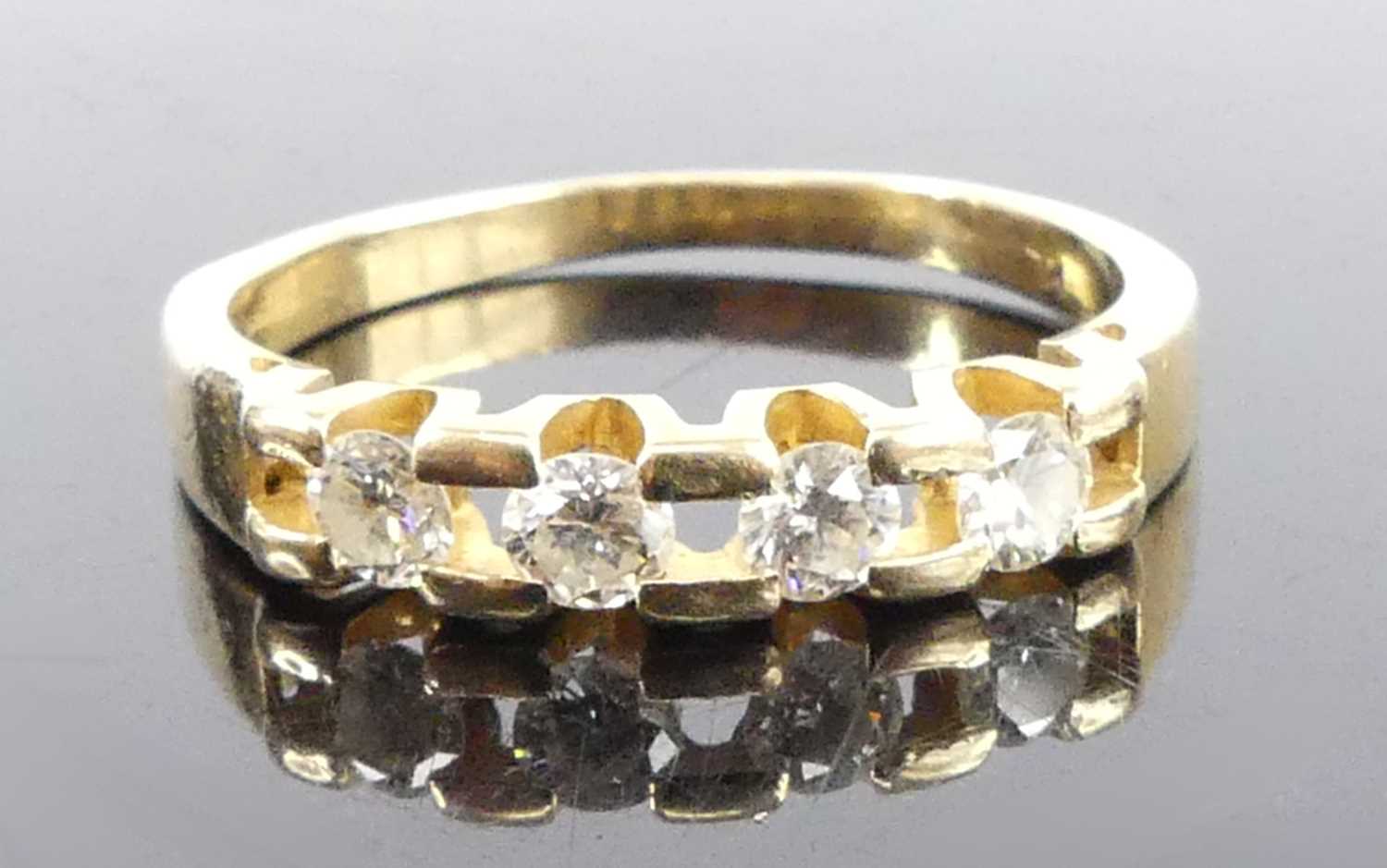 A yellow metal diamond half hoop eternity ring, featuring four round brilliant cut diamonds in