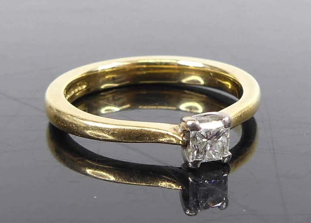 An 18ct yellow and white gold diamond solitaire ring, comprising a princess cut diamond in a four-