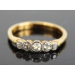 A yellow metal diamond set half hoop ring, arranged as five graduated bezel set round cuts, total