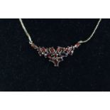 A modern 9ct gold garnet set necklet, the flowerhead setting as an arrangement of marquise and round